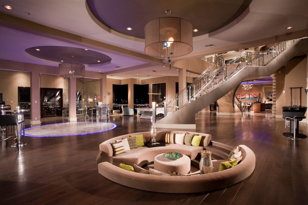 Bright, wide living room with a curved sectional sofa and a spiral staircase